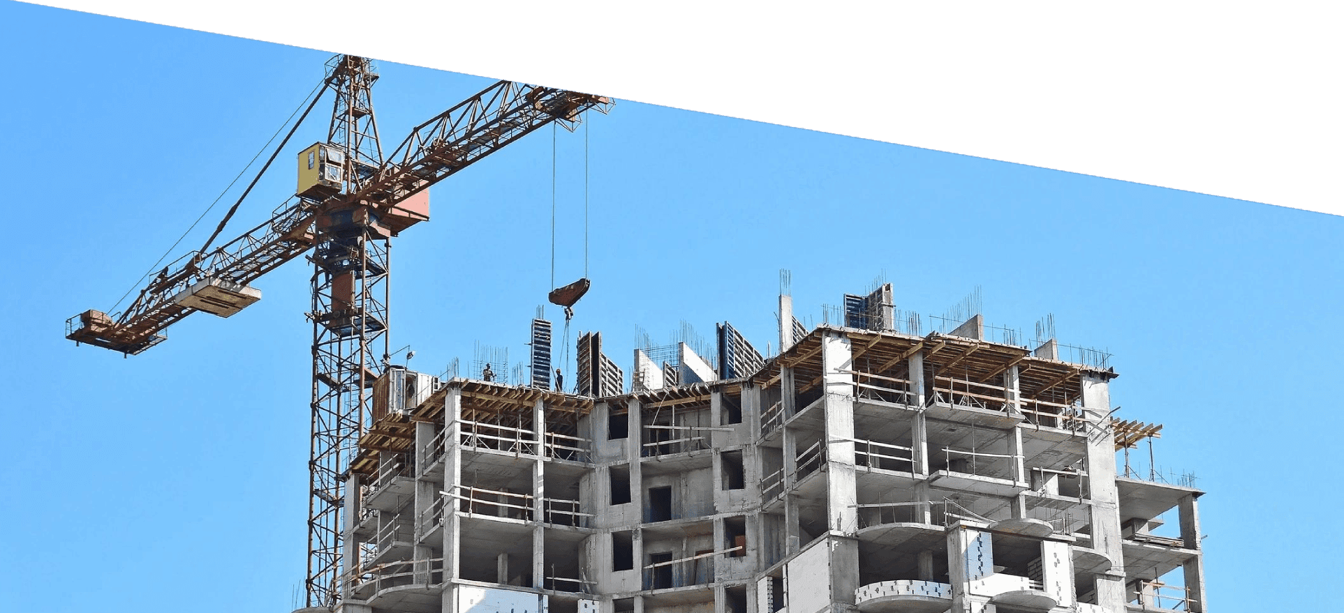 A large crane lifts materials to the top of a new, multistory construction project.